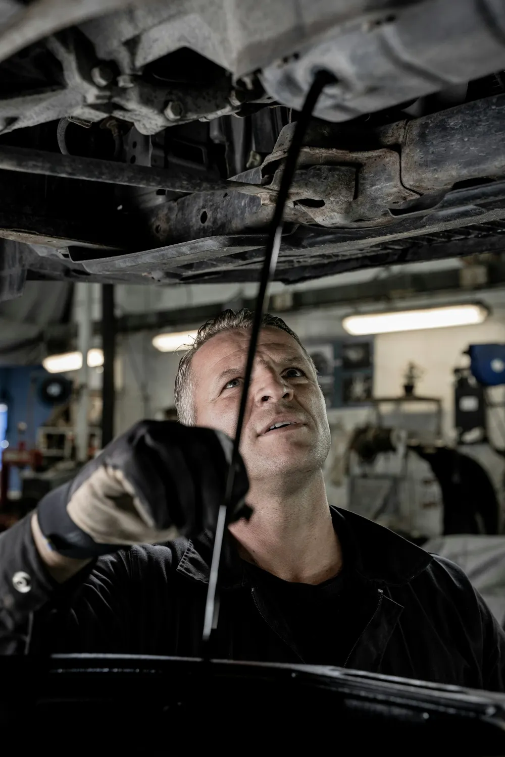 Un meccanico lavora sotto un'auto