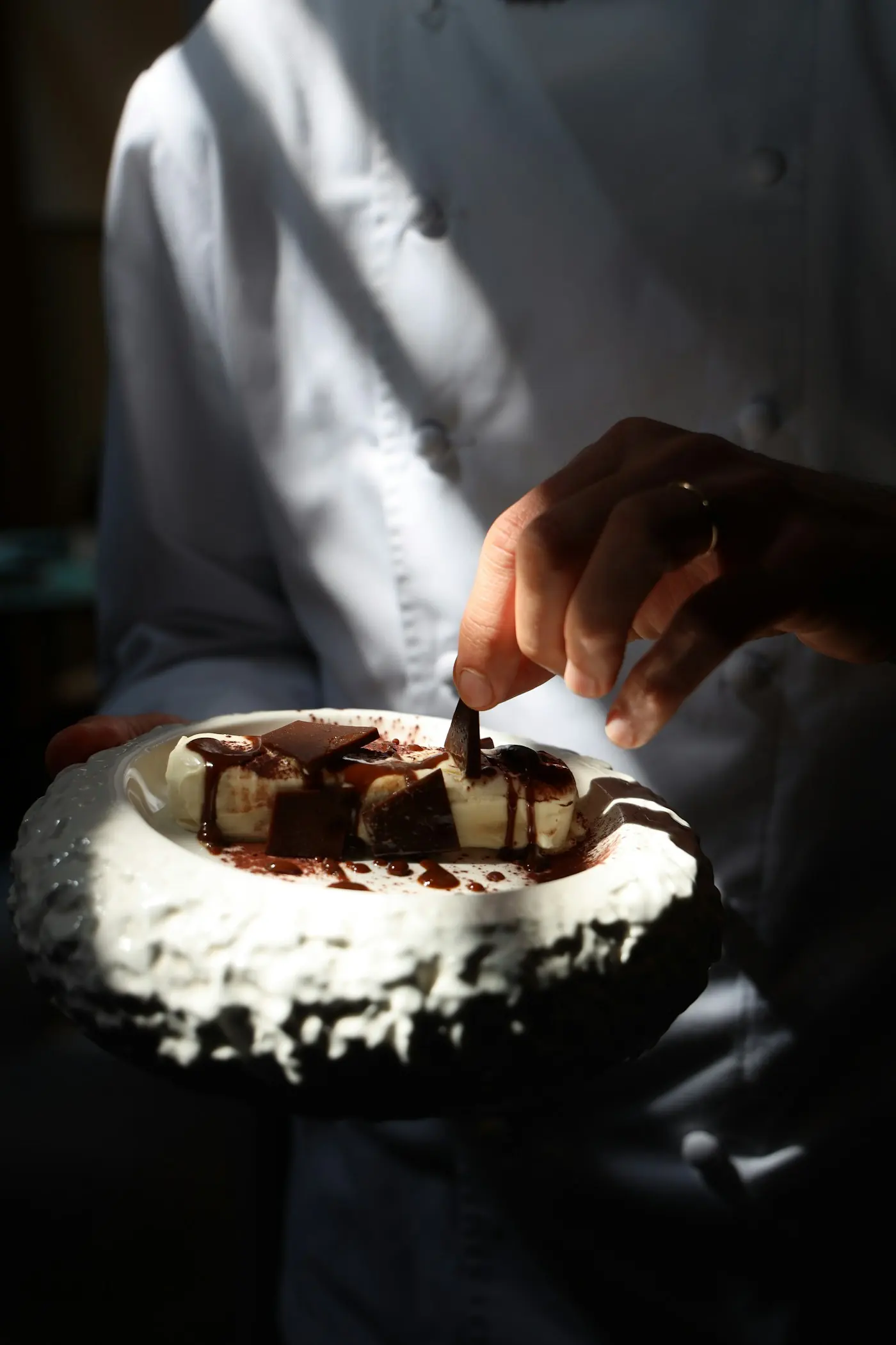 Lo chef guarnisce il dolce al cioccolato
